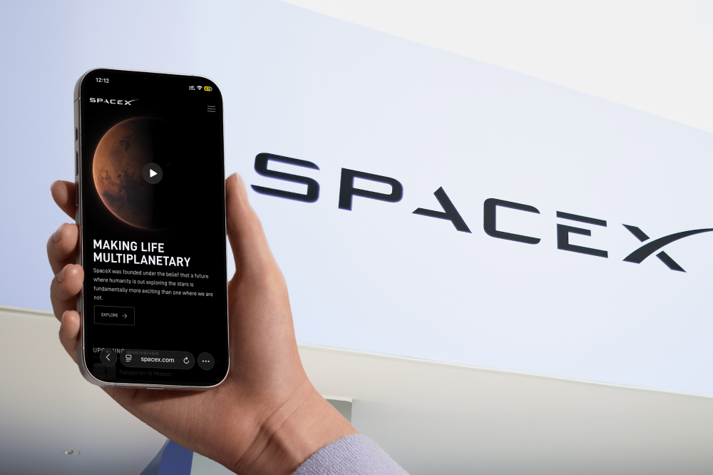 SpaceX website on a smartphone with the slogan "Making Life Multiplanetary" against the SpaceX logo.