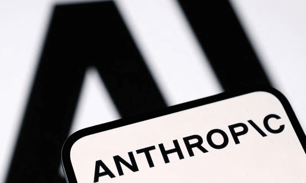 Логотип Anthropic на экране смартфона на размытом черно-белом фоне.