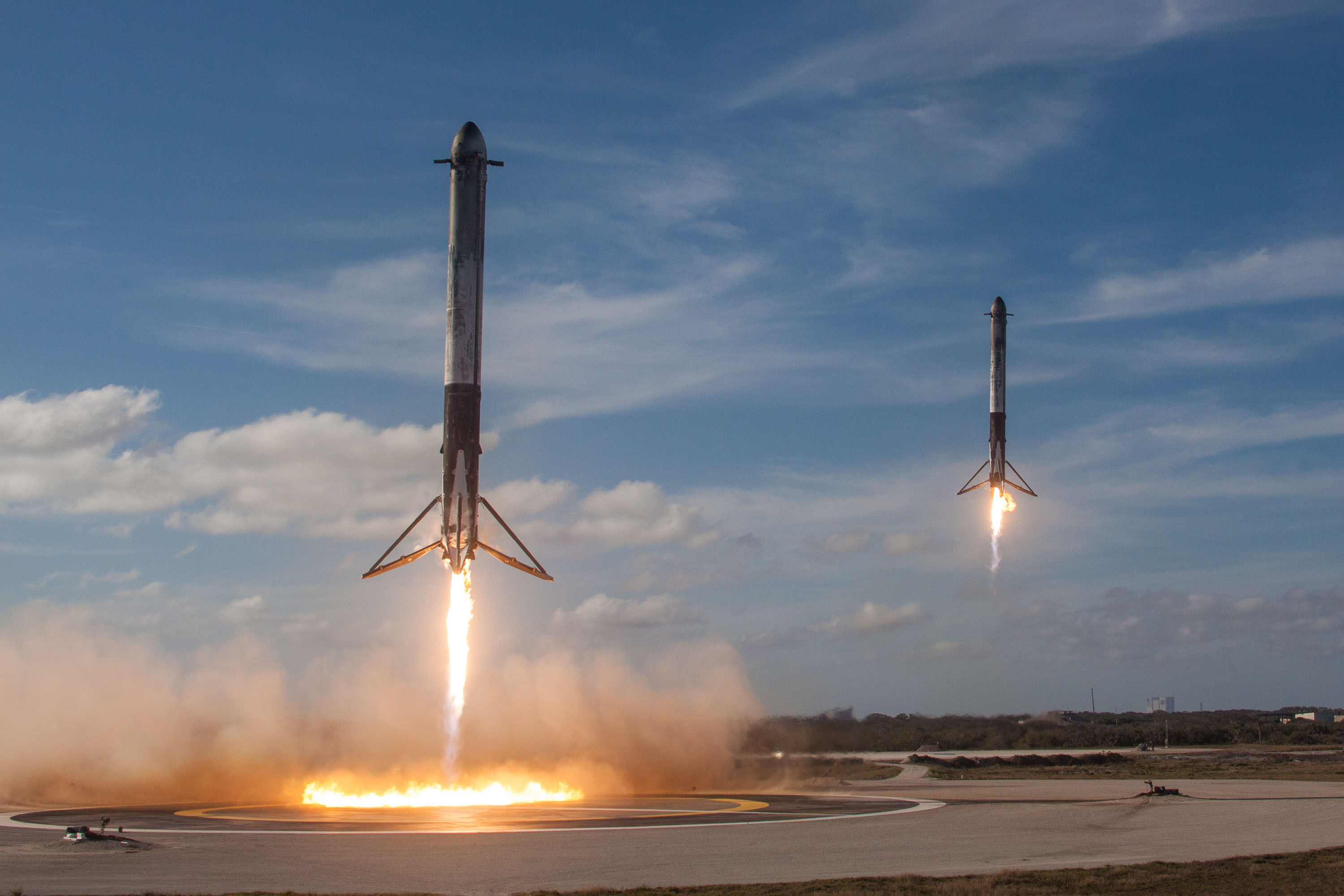 Два боковых ускорителя Falcon Heavy одновременно опускаются на посадочные площадки.