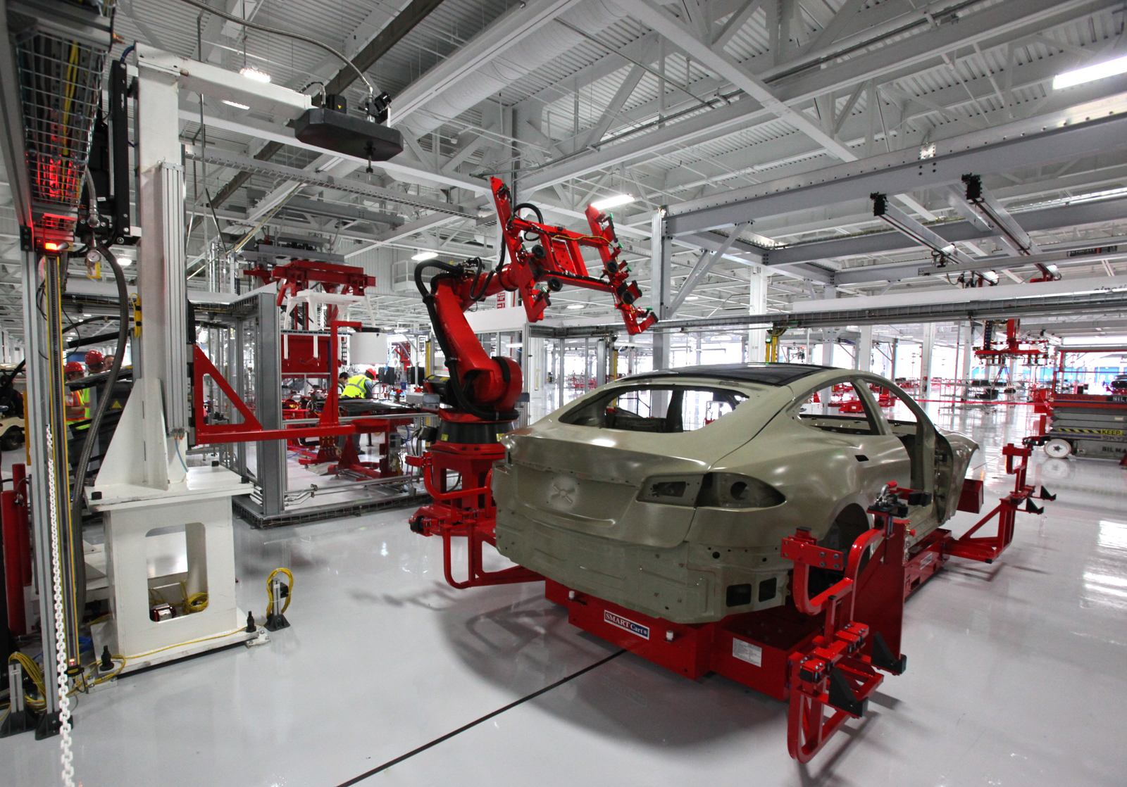 Photo: Steve Jurvetson. CC BY 2.0: https://creativecommons.org/licenses/by/2.0/ Industrial robots working on a Tesla Model S body on the production line in Fremont.
