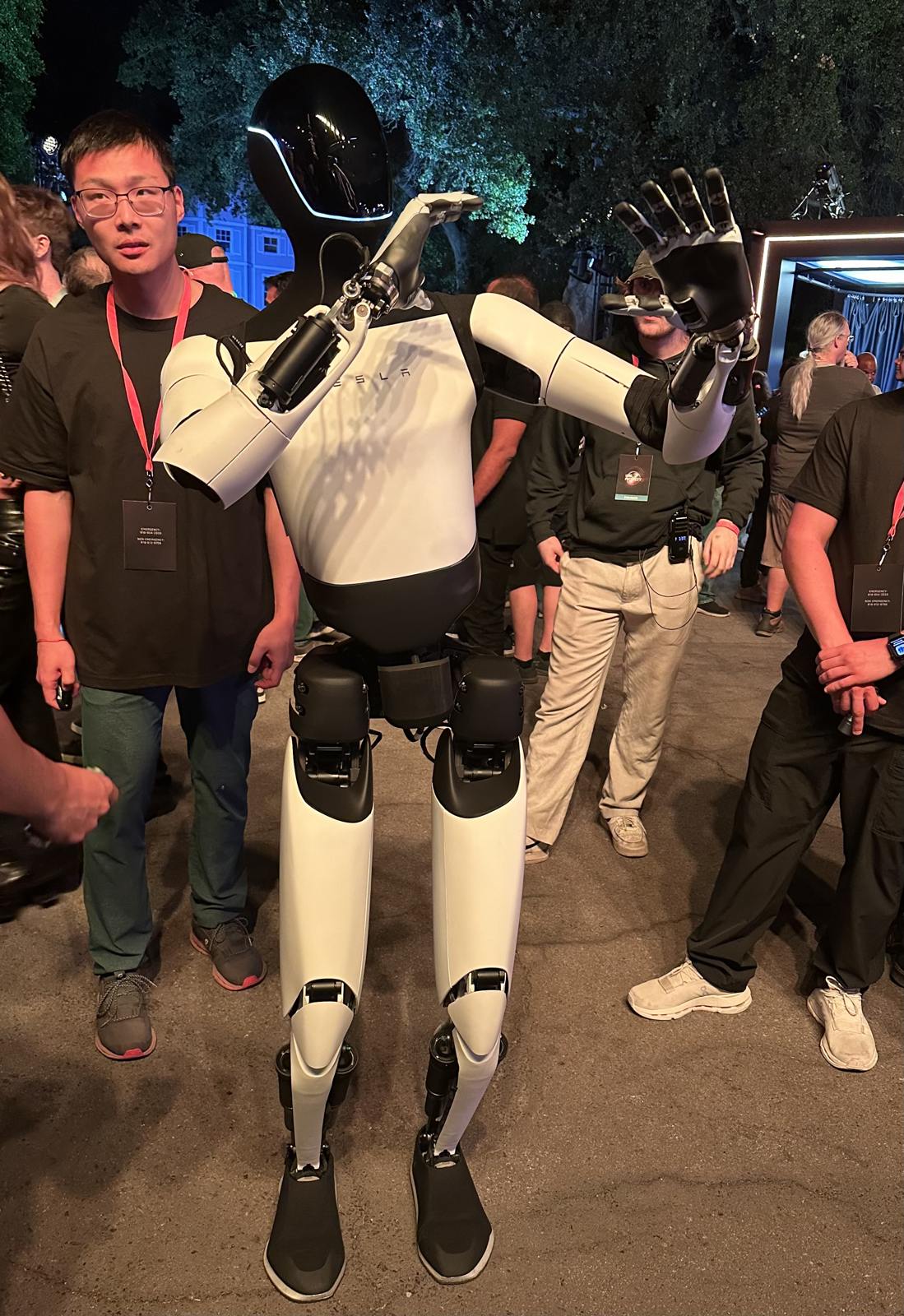 Photo: Steve Jurvetson. CC BY 2.0: https://creativecommons.org/licenses/by/2.0/ A Tesla Optimus humanoid robot among attendees at the Robotaxi unveiling in October 2024.