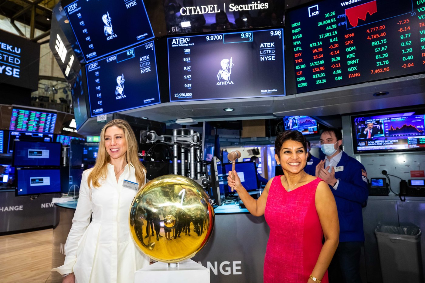 Participants in the Athena Technology Acquisition Corp. II ceremony beside the NYSE bell, with market screens in the background.