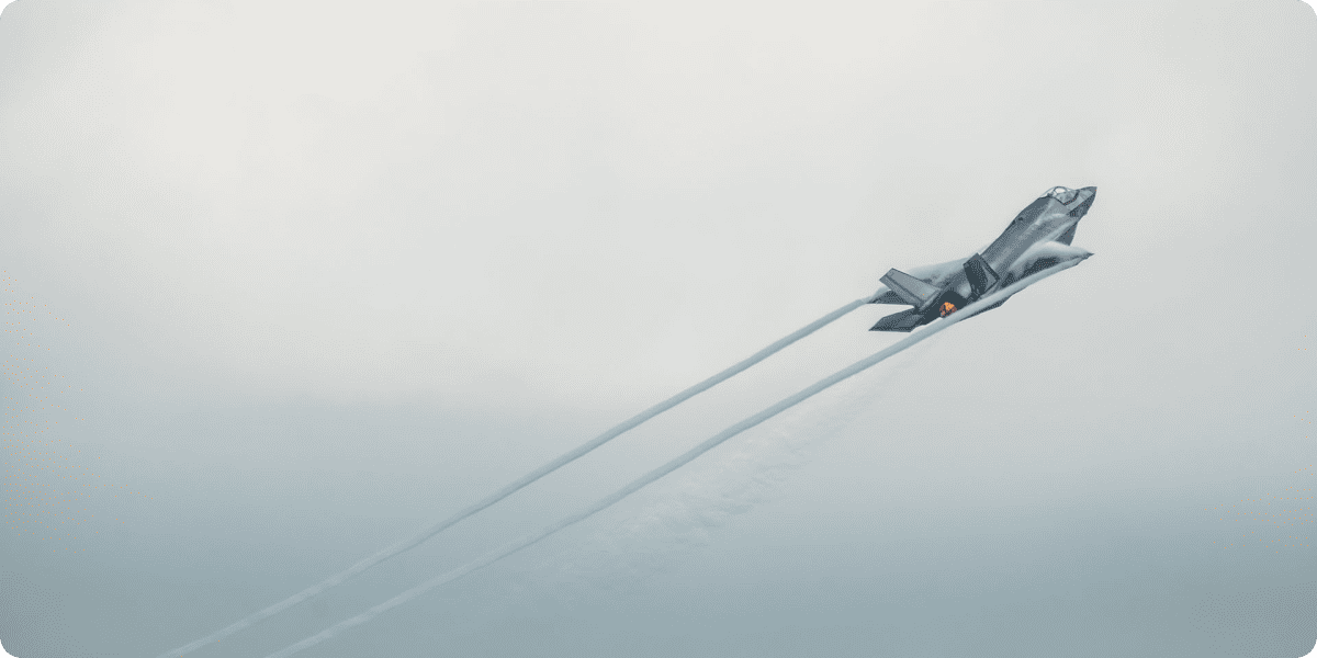 F-35 jet climbing through clouds