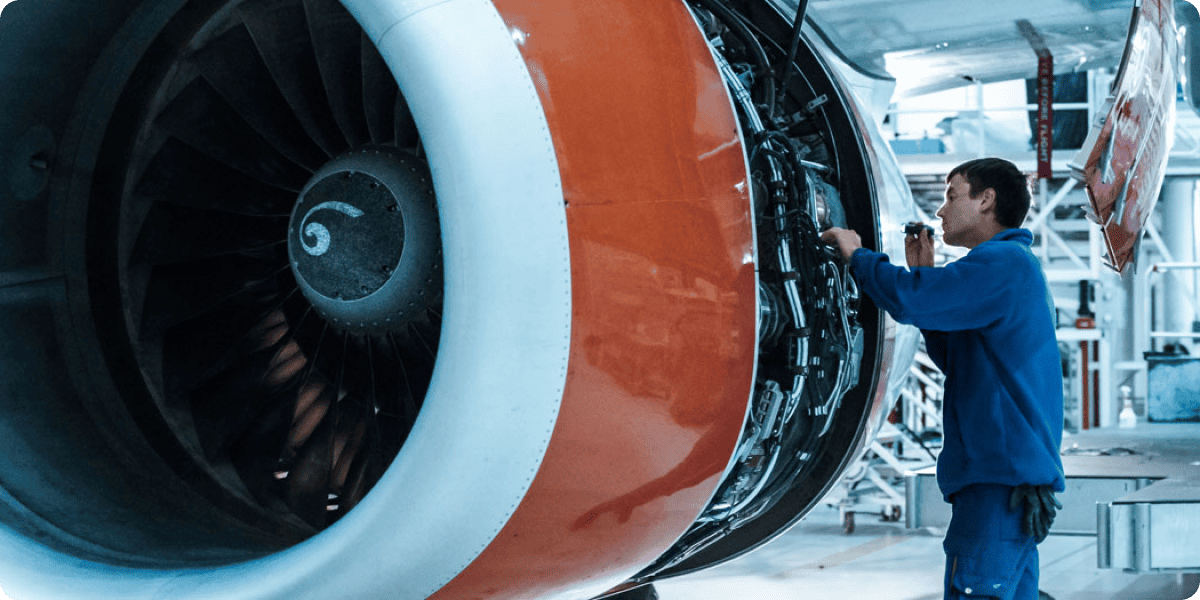Engineer servicing a jet engine in a maintenance hangar